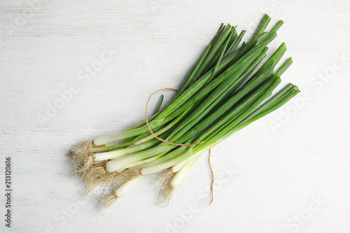 Fresh green onion on wooden table, top view