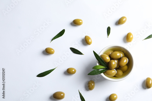 Flat lay composition with fresh olives in oil on white background