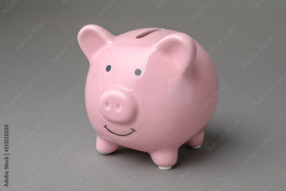 Cute pink piggy bank on gray background