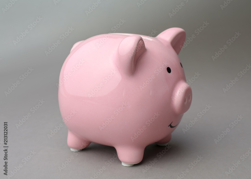 Cute pink piggy bank on gray background Cute pink piggy bank on gray background