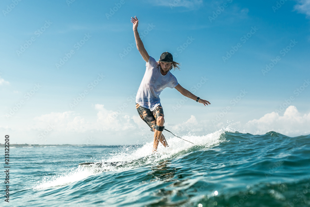 male surfer riding waves in ocean at Nusa Dua Beach, Bali, Indonesia