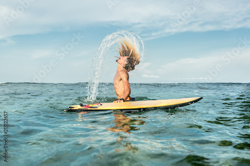 Fotografie side view of shirtless male surfer emerging from water with surfing board in oce