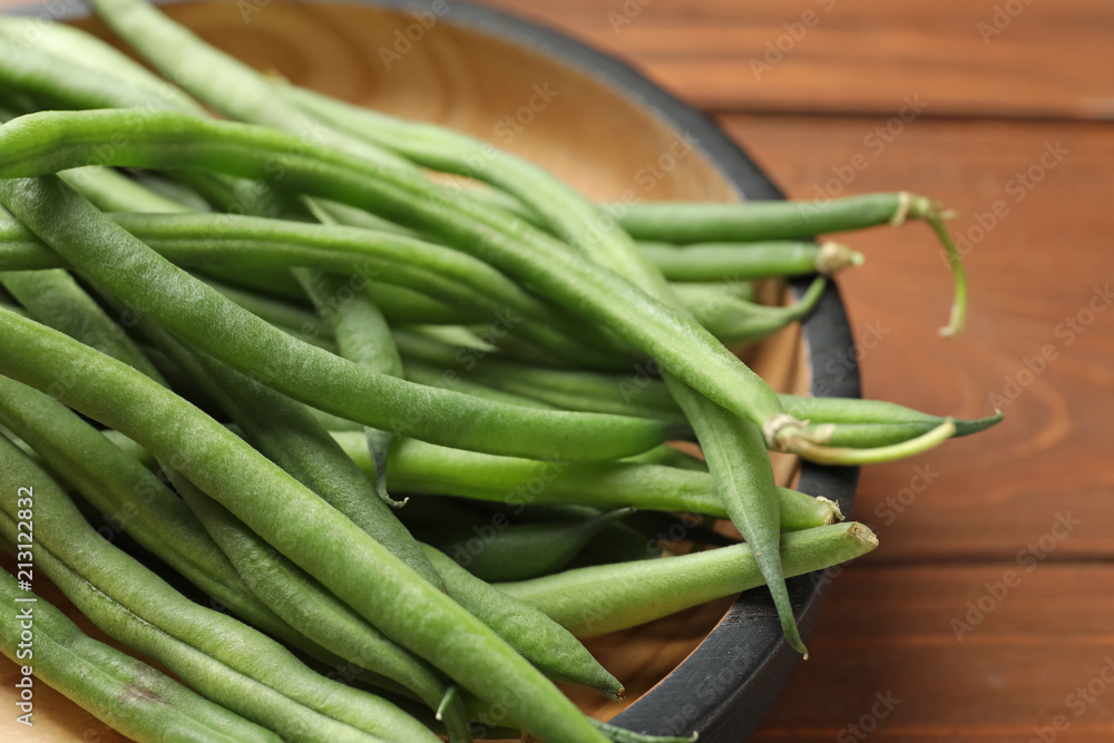 Plate with fresh green French beans on wooden table, closeup Plate with fresh green French beans on wooden table, closeup