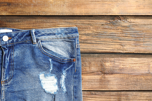 Blue jeans on wooden background, top view