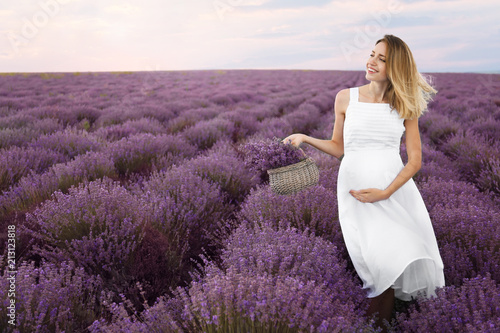 Pregnant woman in lavender field on summer day