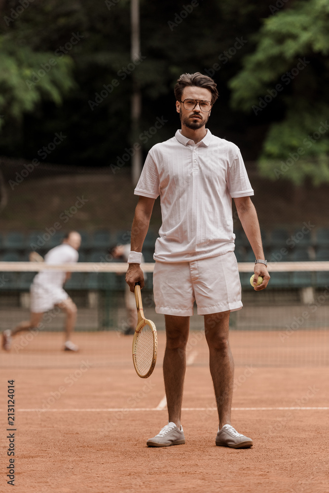 retro styled tennis player standing with racket and ball at court retro styled tennis player standing with racket and ball at court