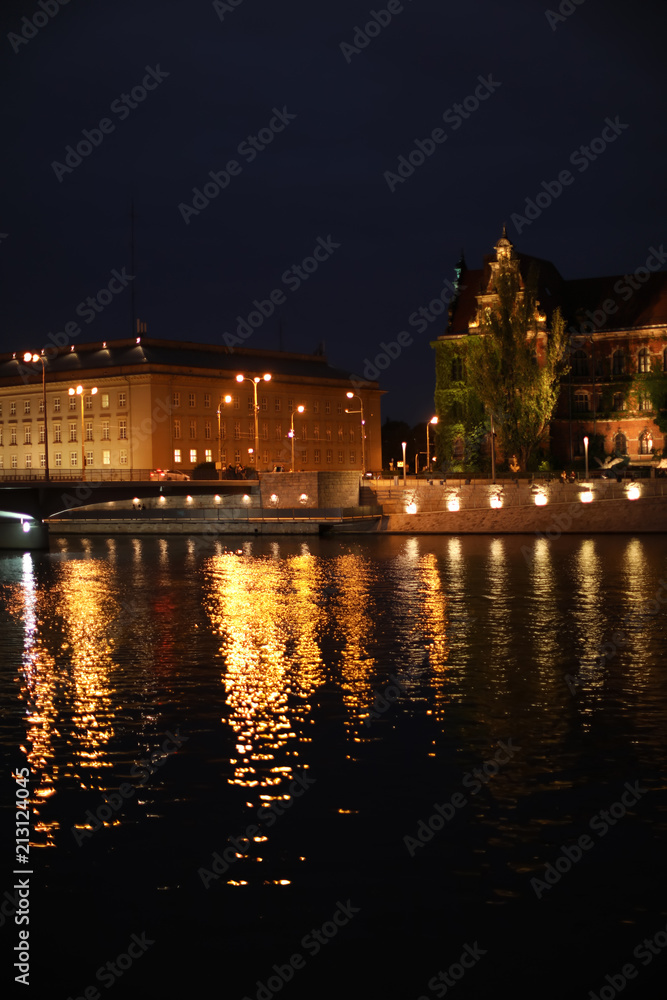Beautiful view of illuminated city near river at night