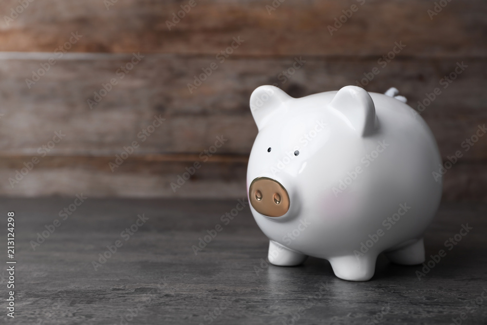 Fototapeta premium White piggy bank on gray table. Money saving
