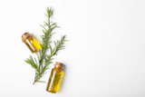 Composition with bottles of rosemary oil on white background, top view