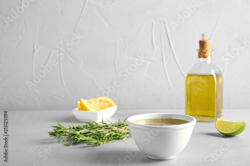 Fototapeta Naklejka Na Ścianę i Meble -  Bowl with fresh rosemary oil on table