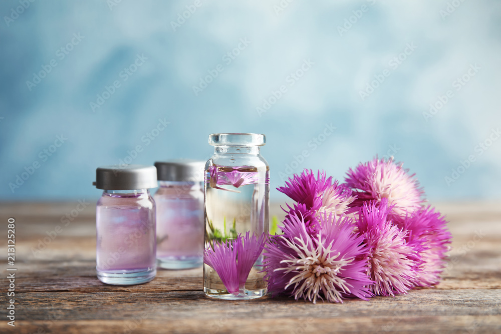 Composition with essential oils and flowers on table Composition with essential oils and flowers on table