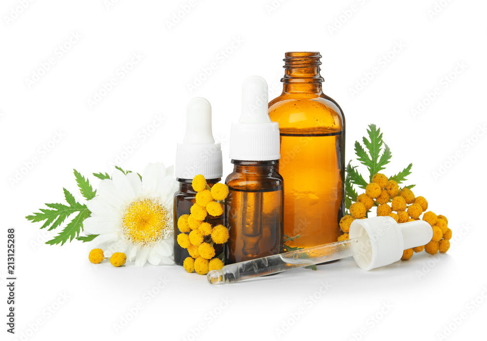 Composition with essential oils and flowers on white background Composition with essential oils and flowers on white background