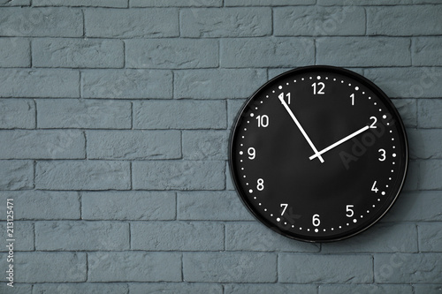 Modern clock on brick wall. Time concept