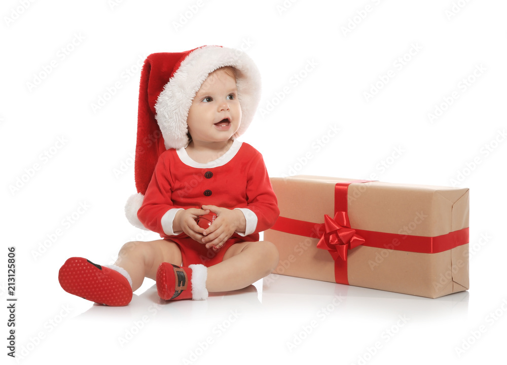 Cute little baby in Christmas costume and gift on white background Cute little baby in Christmas costume and gift on white background