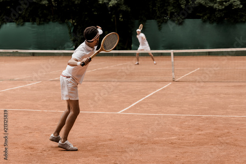 retro styled tennis players playing at tennis court © LIGHTFIELD STUDIOS