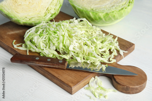 Cutting board with chopped and sliced cabbage on table