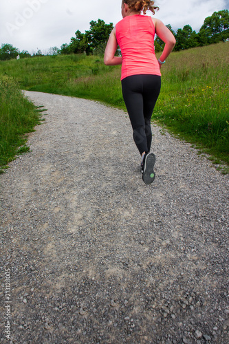 Young woman running along path