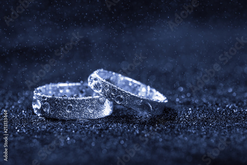 Wallpaper Mural Two wedding rings with water drops on blue background with copy space. Torontodigital.ca