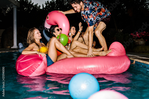 Group of happy friends partying in a swimming pool