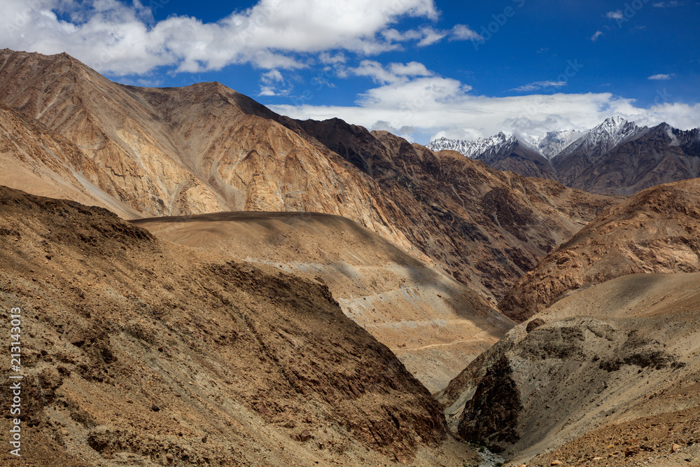 Fototapeta premium ChangLa Pass, Ladakh India. High Altitude mountain pass, snow mountains in the background with a canyon/valley in the foreground. Road between Zingral and Durbuk. Grand landscape with huge mountains.
