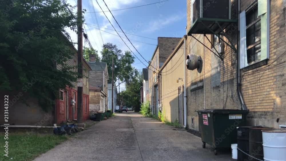 A daytime summer establishing shot of an empty alley in a small rust belt Ohio valley town. Pittsburgh suburbs. A daytime summer establishing shot of an empty alley in a small rust belt Ohio valley town. Pittsburgh suburbs.