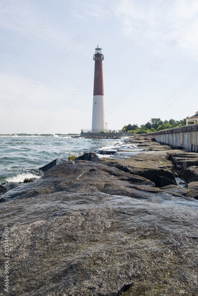 Obraz premium lighthouse in New Jersey provides warning light on island for ships navigating through ocean channels
