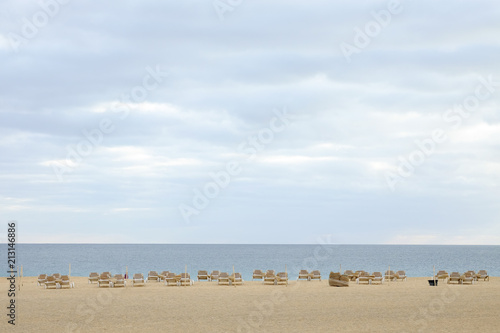 Beach with white sand and sunbeds and view on the sea