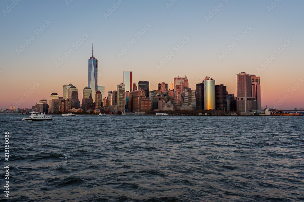 New York city skyline sunset view from the boat to Ellis Island