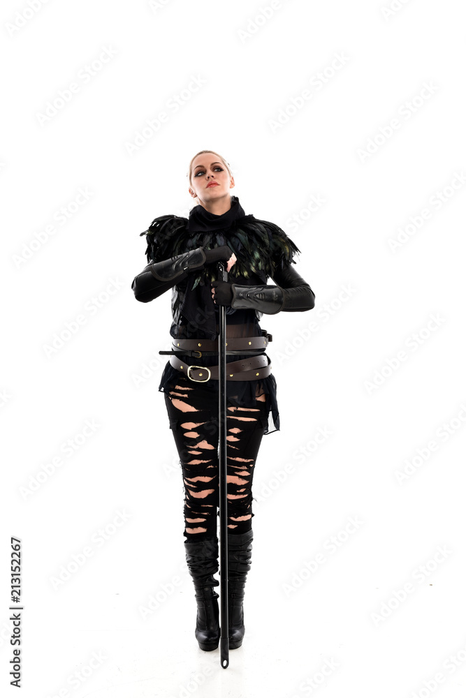 full length portrait of blonde girl wearing black gothic outfit, holding a staff. standing pose, isolated on white studio background. full length portrait of blonde girl wearing black gothic outfit, holding a staff. standing pose, isolated on white studio background.