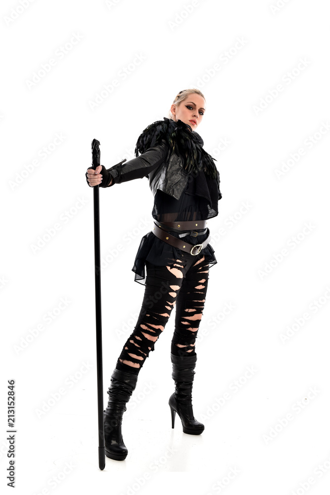 full length portrait of blonde girl wearing black gothic outfit, holding a staff. standing pose, isolated on white studio background. full length portrait of blonde girl wearing black gothic outfit, holding a staff. standing pose, isolated on white studio background.