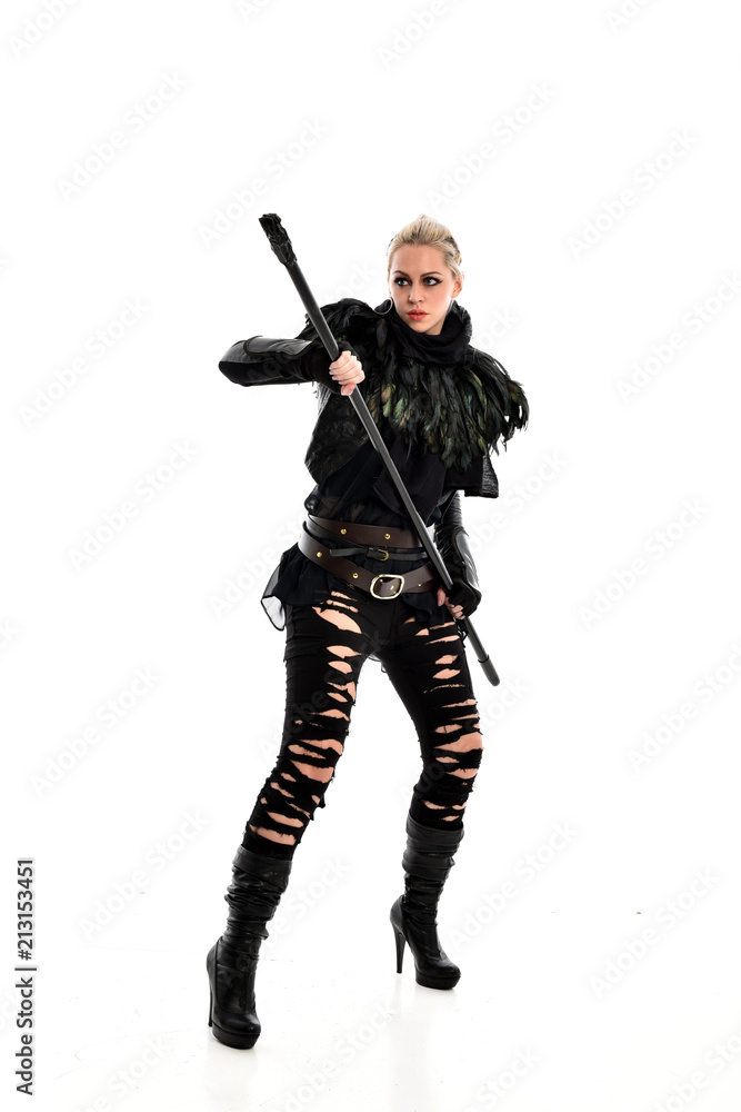 full length portrait of blonde girl wearing black gothic outfit, holding a staff. standing pose, isolated on white studio background. full length portrait of blonde girl wearing black gothic outfit, holding a staff. standing pose, isolated on white studio background.