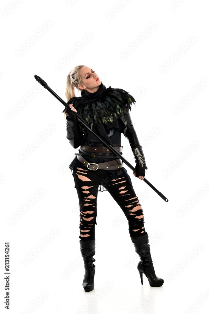 full length portrait of blonde girl wearing black gothic outfit, holding a staff. standing pose, isolated on white studio background. full length portrait of blonde girl wearing black gothic outfit, holding a staff. standing pose, isolated on white studio background.