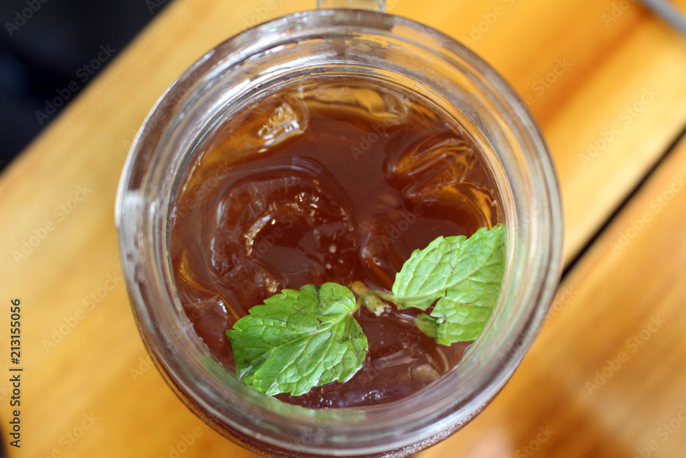 A cup of ice lemon tea with its leaf, served at a cafe A cup of ice lemon tea with its leaf, served at a cafe