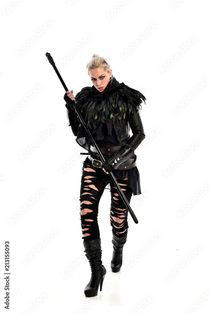 full length portrait of blonde girl wearing black gothic outfit, holding a staff. standing pose, isolated on white studio background. full length portrait of blonde girl wearing black gothic outfit, holding a staff. standing pose, isolated on white studio background.