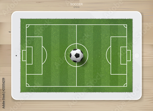 Soccer football ball in soccer field area on tablet display with wood texture background. For create soccer game and soccer football tactic idea. Vector.