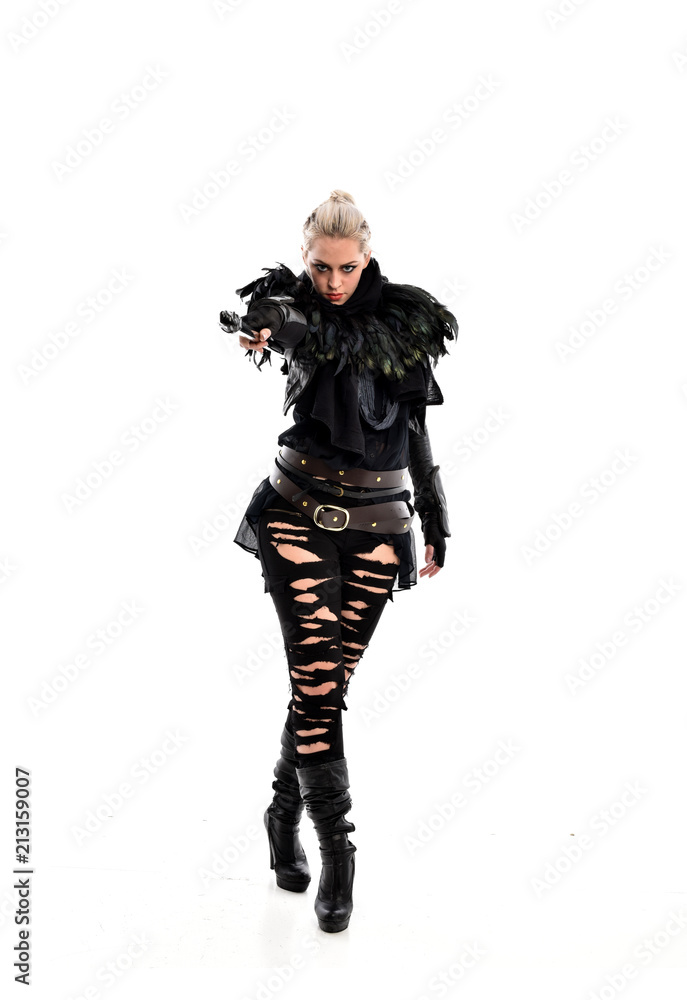 full length portrait of blonde girl wearing black gothic outfit, holding a staff. standing pose, isolated on white studio background. full length portrait of blonde girl wearing black gothic outfit, holding a staff. standing pose, isolated on white studio background.