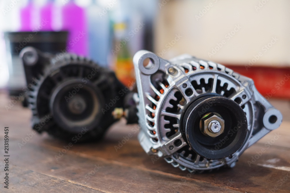New and old automotive power generator alternator for car on wooden table background. New and old automotive power generator alternator for car on wooden table background.