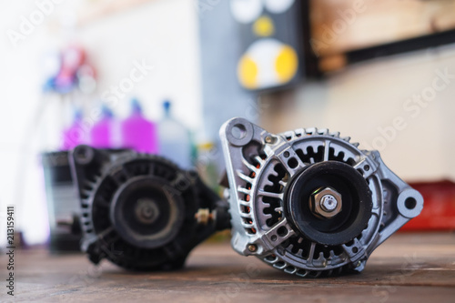 New and old automotive power generator alternator for car on wooden table background.