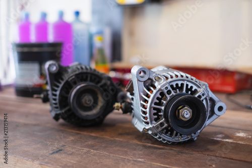 New and old automotive power generator alternator for car on wooden table background.