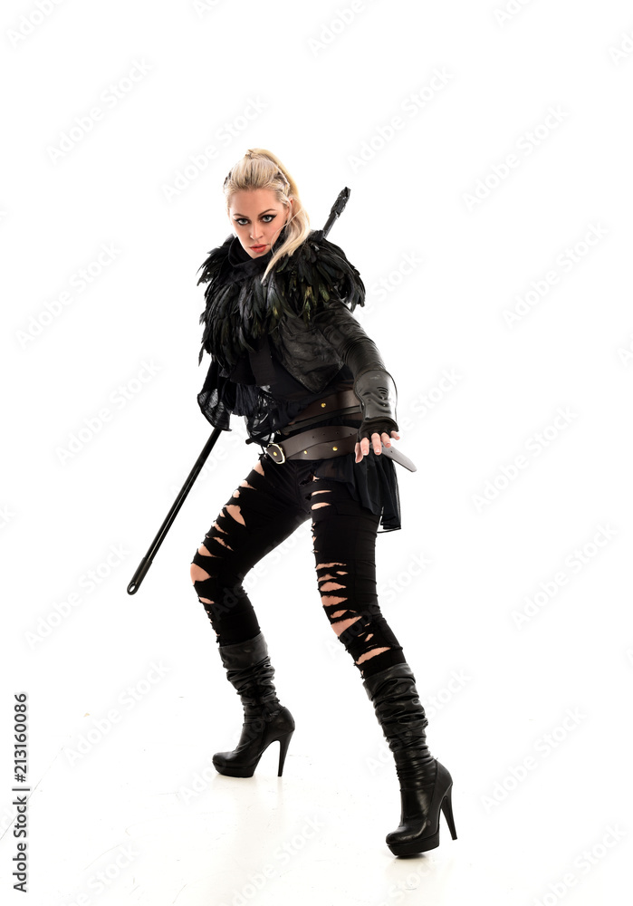 full length portrait of blonde girl wearing black gothic outfit, holding a staff. standing pose, isolated on white studio background. full length portrait of blonde girl wearing black gothic outfit, holding a staff. standing pose, isolated on white studio background.