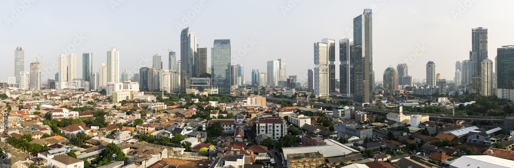 Stunning panorama of Jakarta South Central Business district contrasting with low rise residential middle class housing area in Indonesia capital city in Southeast Asia