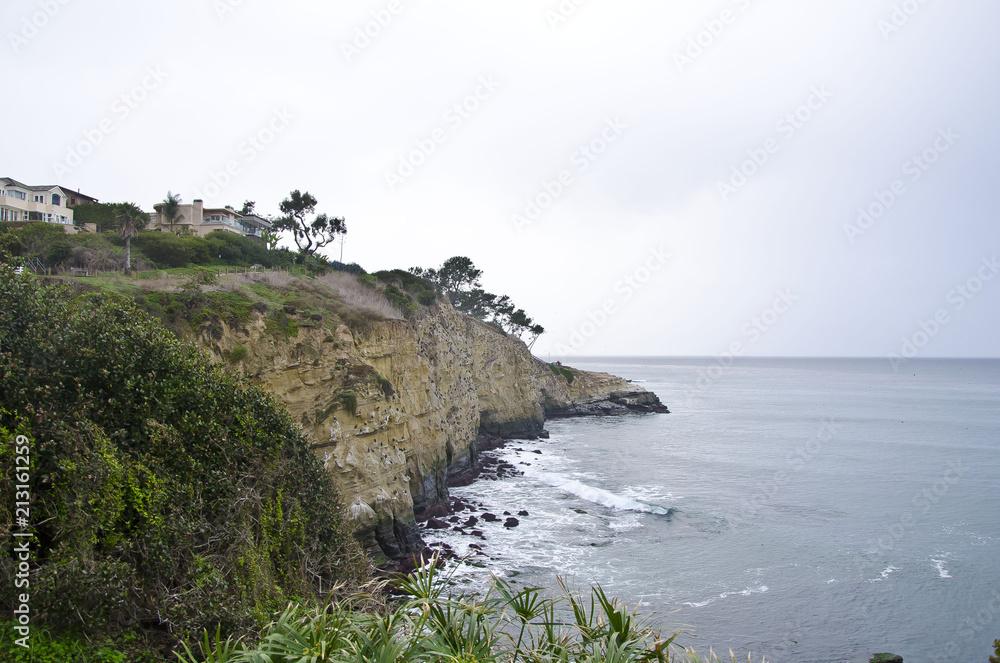 The long out crop of the la jolla state beach cliffs on a overcast day. 