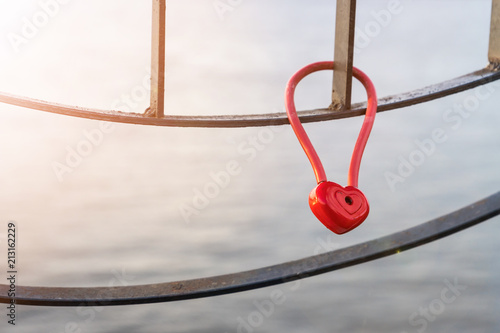 A padlock in the shape of a heart on a metal fence. A symbol of love and fidelity.