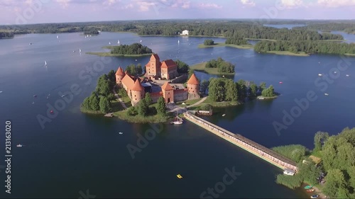 Aerial footage captured by a drone over a beautiful lake with a castle in its center. photo