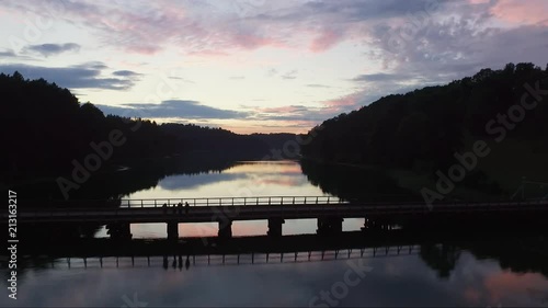 Aerial footage captured by a drone over a lake and a bridge, at the twilight hours. photo