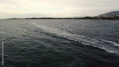 Flying over the sea on a cloudy day. Small island on the horizon. photo