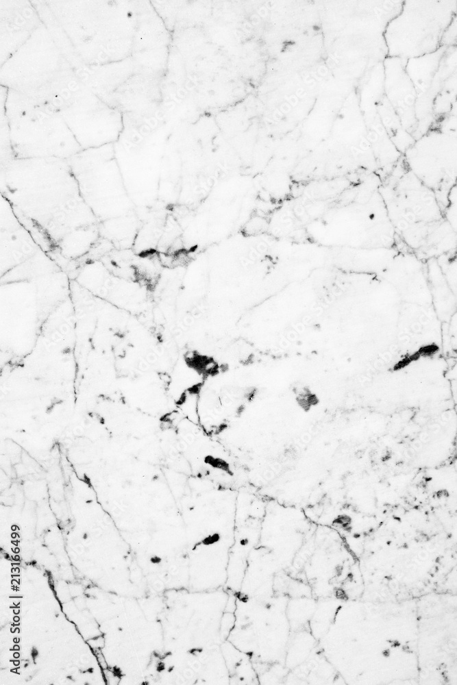 Polished surface of white marble with dark veins and specks