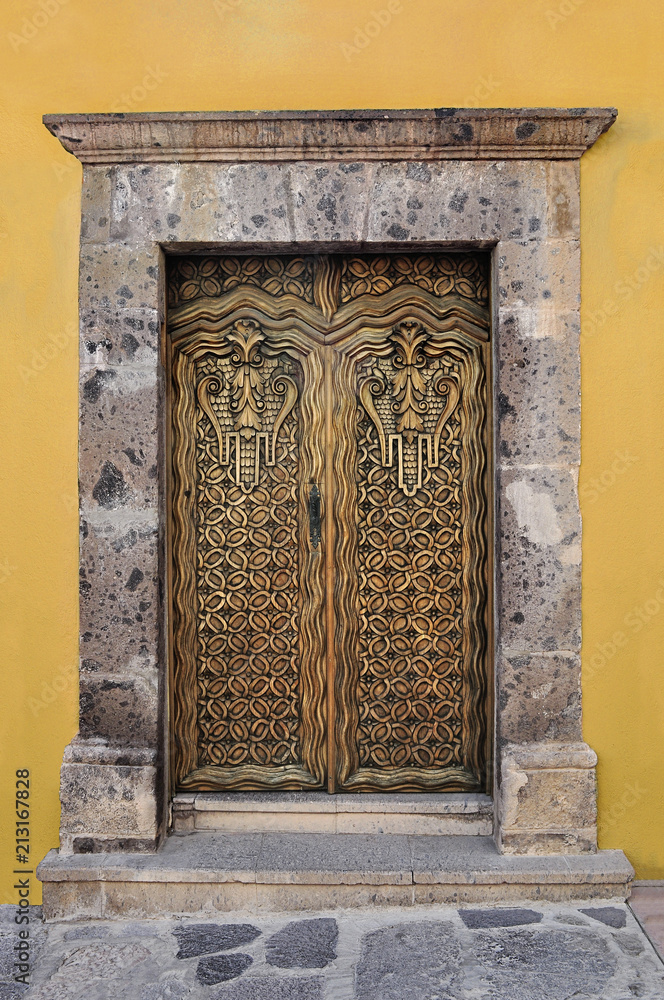 Fototapeta premium Artistically carved wooden door, Colonial style house in san Miguel de Allende Mexico