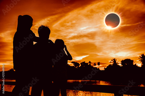 Natural phenomenon. Three person looking at total solar eclipse.