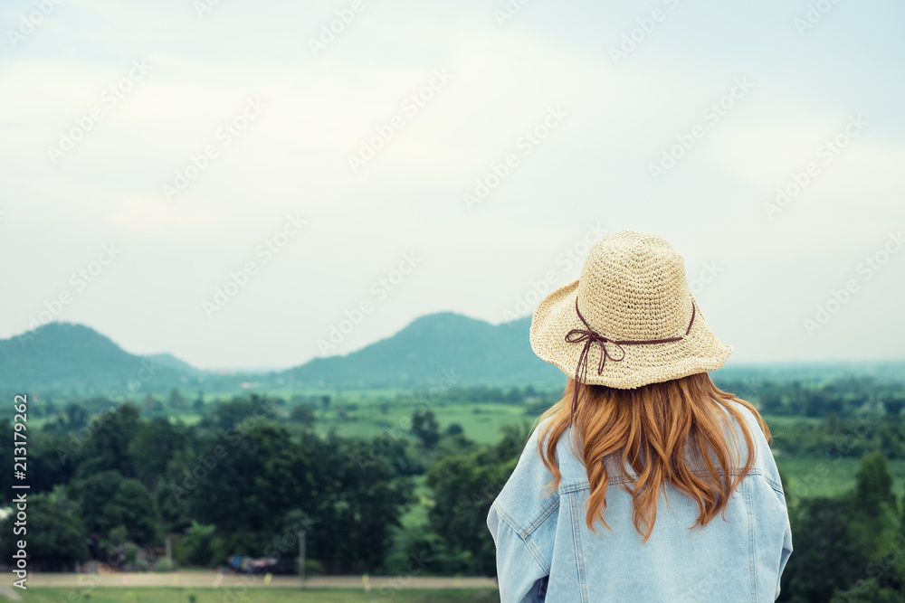 Young beautiful women hipster style wearing hat enjoy life looking mountain with blue sky.